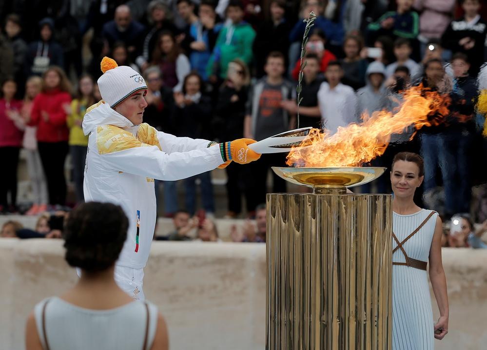 Олимпийский огонь современных игр зажигается. Церемония зажжения олимпийского огня. Ритуал зажжения олимпийского огня в Греции. Эстафета олимпийского огня Греция. Традиция зажжения олимпийского огня в древней Греции.
