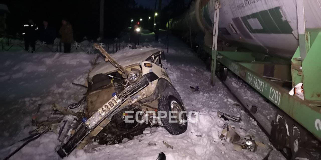 В Киеве на переезде товарный поезд врезался в ВАЗ, пассажира вырвало из  салона и тянуло около километра