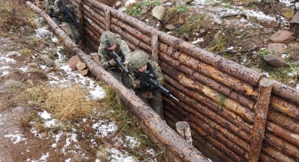 Spanish soldiers practice storming trenches