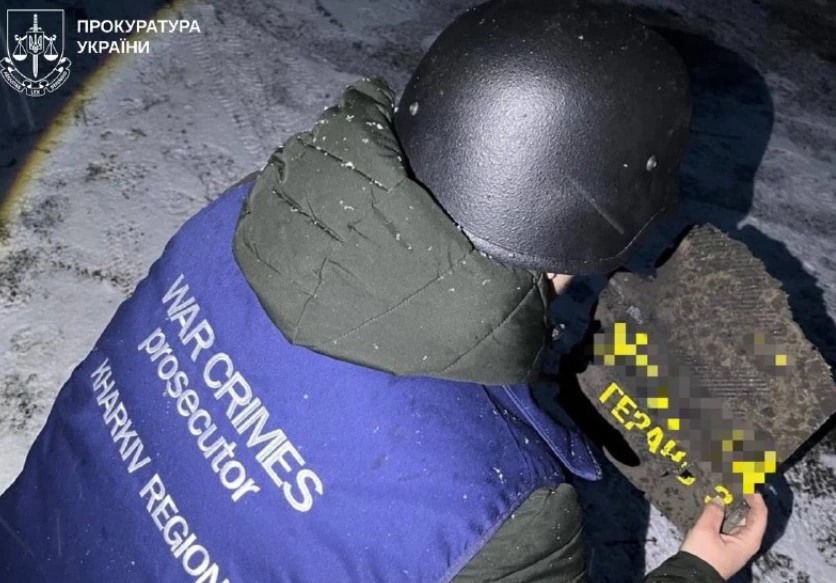 Правоохоронець тримає в руках уламок російського БПЛА "Герань" (Лозова, 10.01.2026)