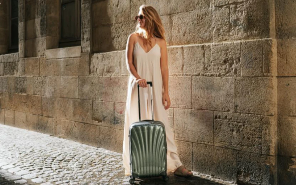 Жінка з валізою samsonite