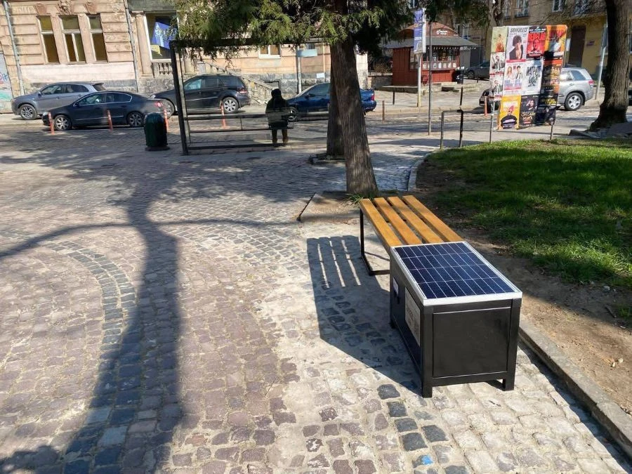 Лавки з сонячними панелями з підзарядки пристроїв поручз з Бернардинським собором