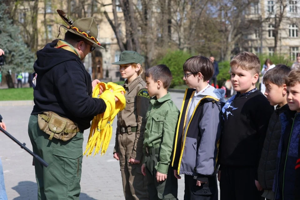 На фото: пластовий провідник вручає новим учасникам жовті хустини на святкуванні 114-річчя Пласту у Львові, 4 квітня 2026 року