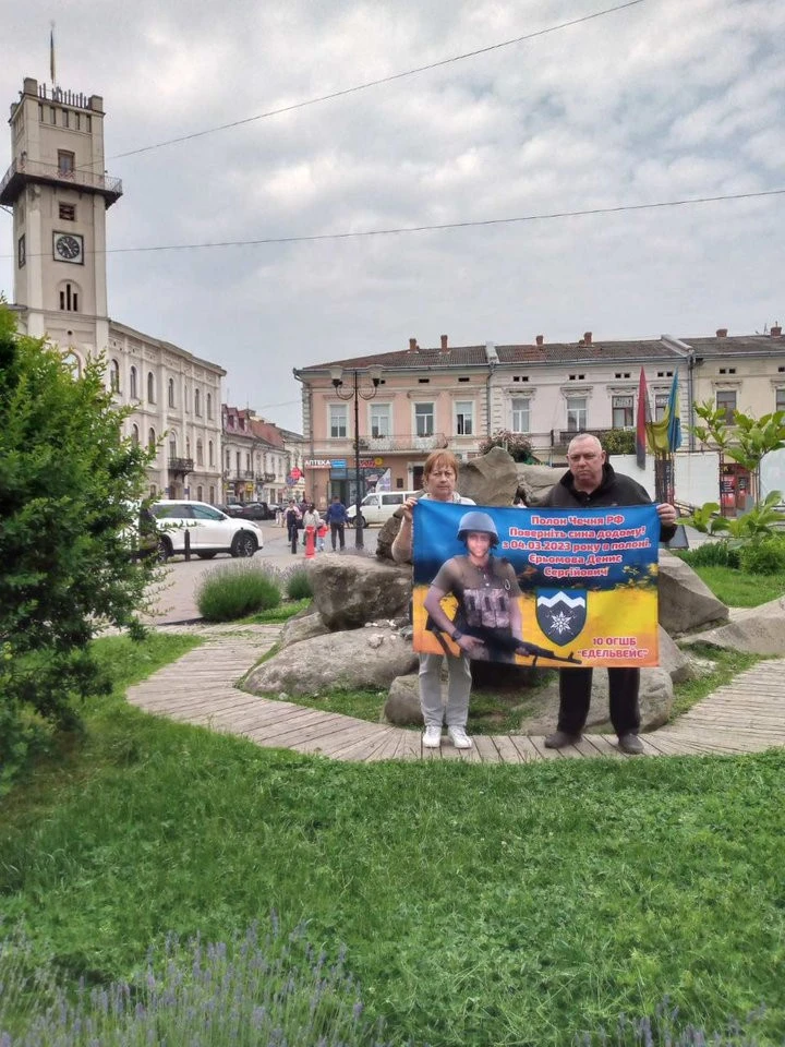 Сергій Єрьомов із матір'ю Дениса тримають прапор