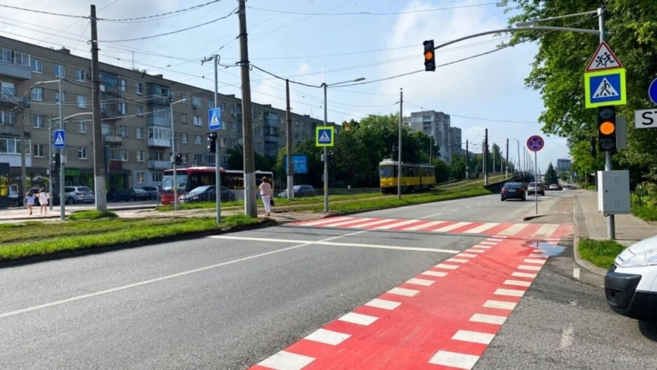 Міська вулиця з регульованим пішохідним переходом, який має яскраву червоно-білу розмітку